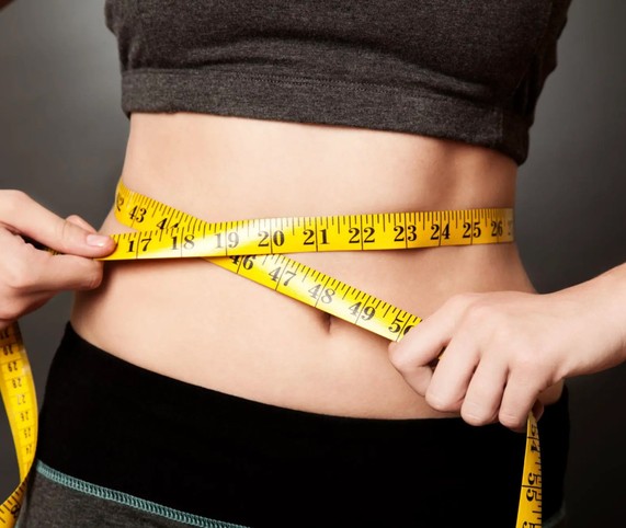 measuring tape wrapped around woman belly